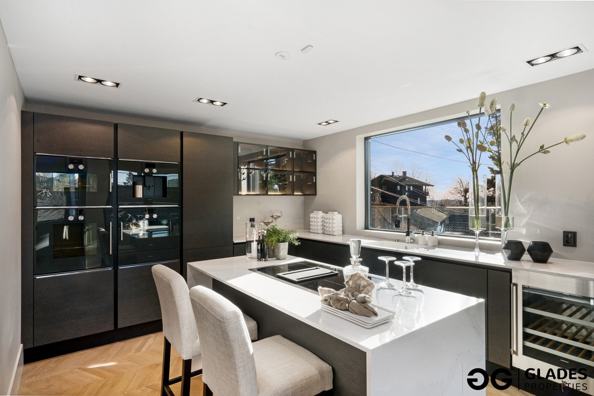 Koketoppen er av det eksklusive slaget, med integrert avtrekk. Videre har kjøkkenet tre ulike stekeovner med damp og mikro, samt varmeskuff, kaffemaskin, vinskap, oppvaskmaskin og kjøl/frys. Alt fra Gaggenau. Galleribilde