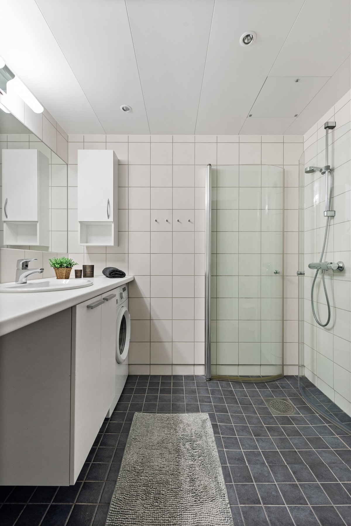 Badet har gulvvarme og opplegg for vaskemaskin og tørketrommel under benkeplate. Downlights i himling. Galleribilde