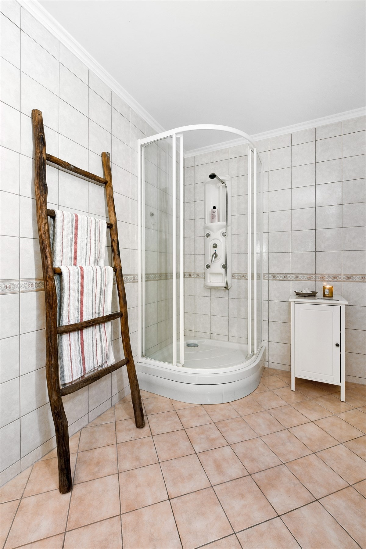 Badet har flislagte overflater, gulvvarme og praktisk nisje for vaskesøyle. Galleribilde