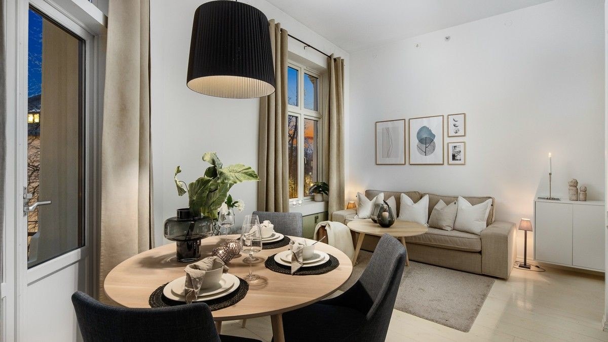 Den innbydende stuen er et naturlig samlingspunkt i leiligheten, og de store vindusflatene sørger at rommet fremstår både lyst og luftig Galleribilde