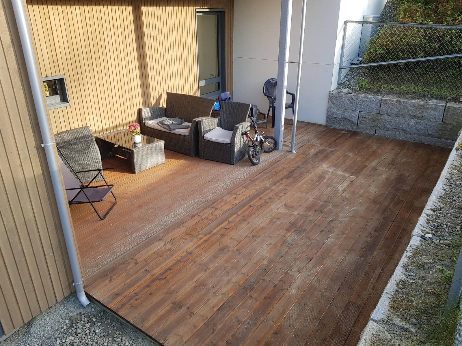 Stor skjermet terrasse med ettermiddagssol. Halvparten av terrassen er under tak. Galleribilde