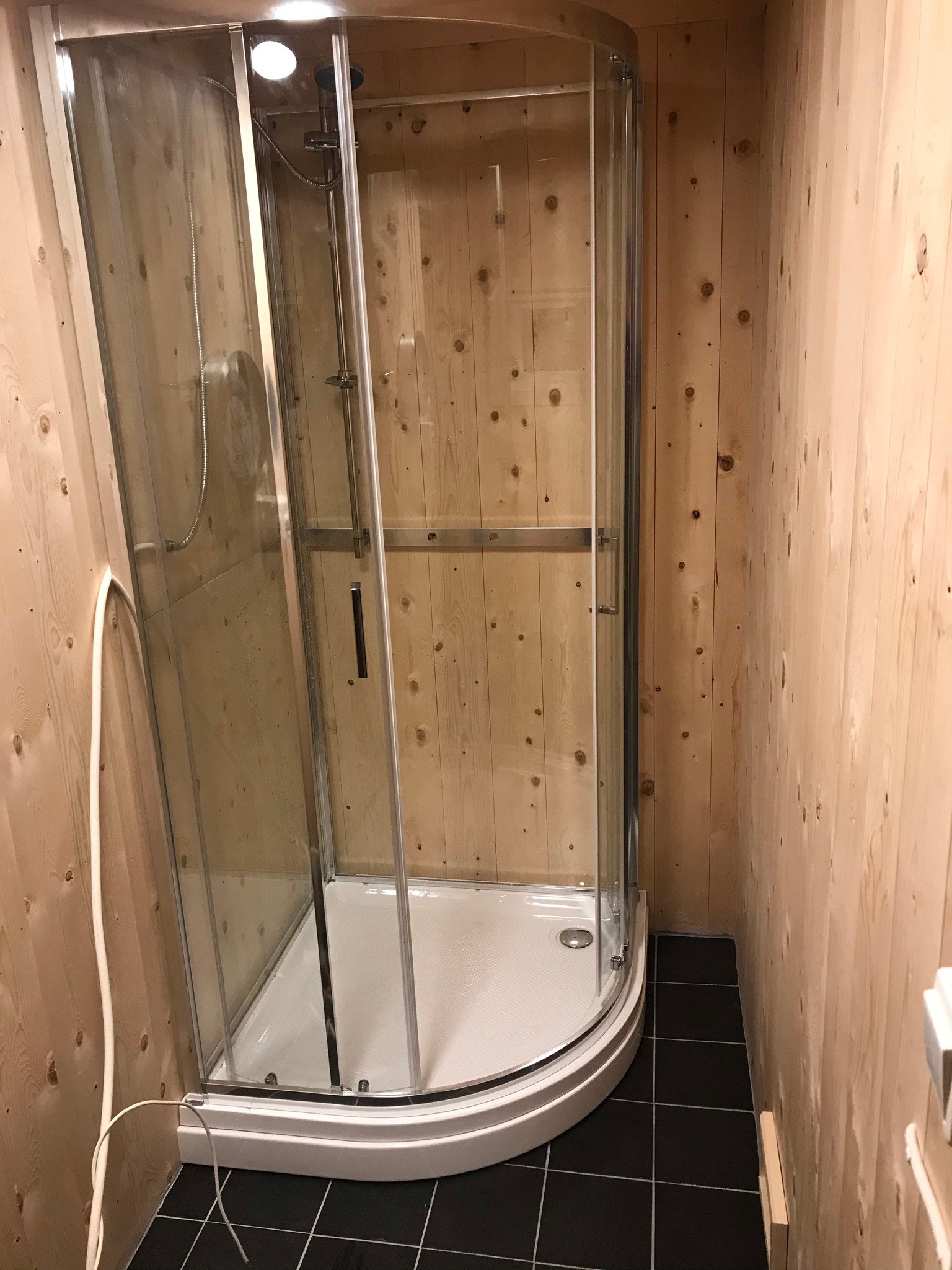 Uthus: dusjrom og forrom til badstue - vann til dusj blandes i 50-liters dunk ved dusjen. Elektrisk pumpe fra dunk til dusj. Varmekabler i gulv. Galleribilde