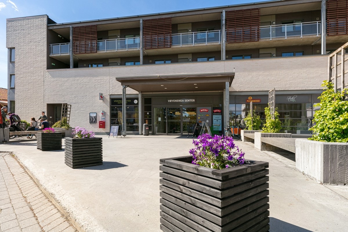 Nede på flaten ligger Vøyenenga senter med både dagligvare, apotek, bespisning og treningssenter Galleribilde