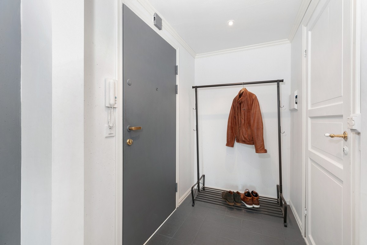 Entréen har fliser på gulv, og en brann -og lydklassifisert inngangsdør Galleribilde