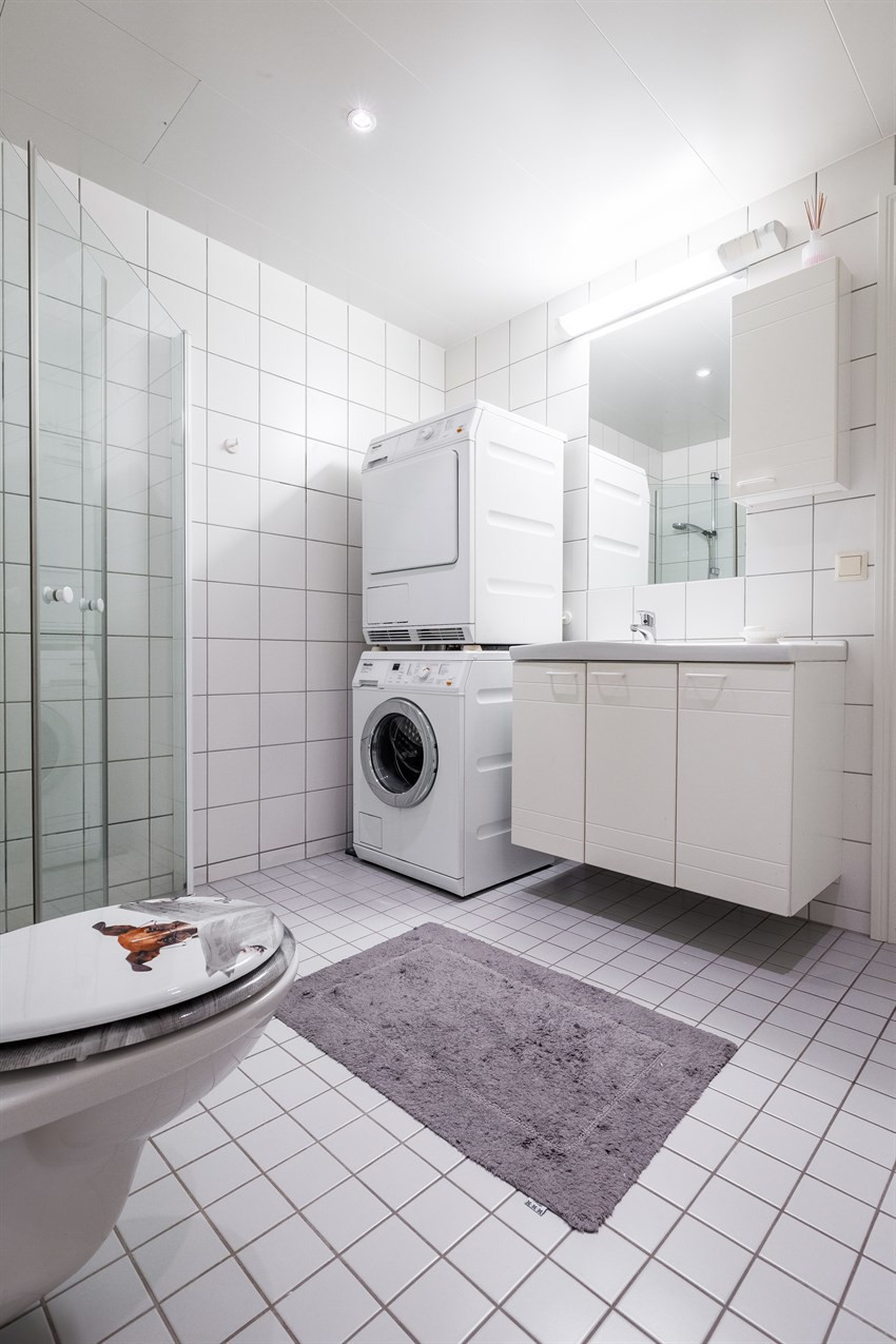 Badet inneholder vegghengt wc, servant og dusjhjørne