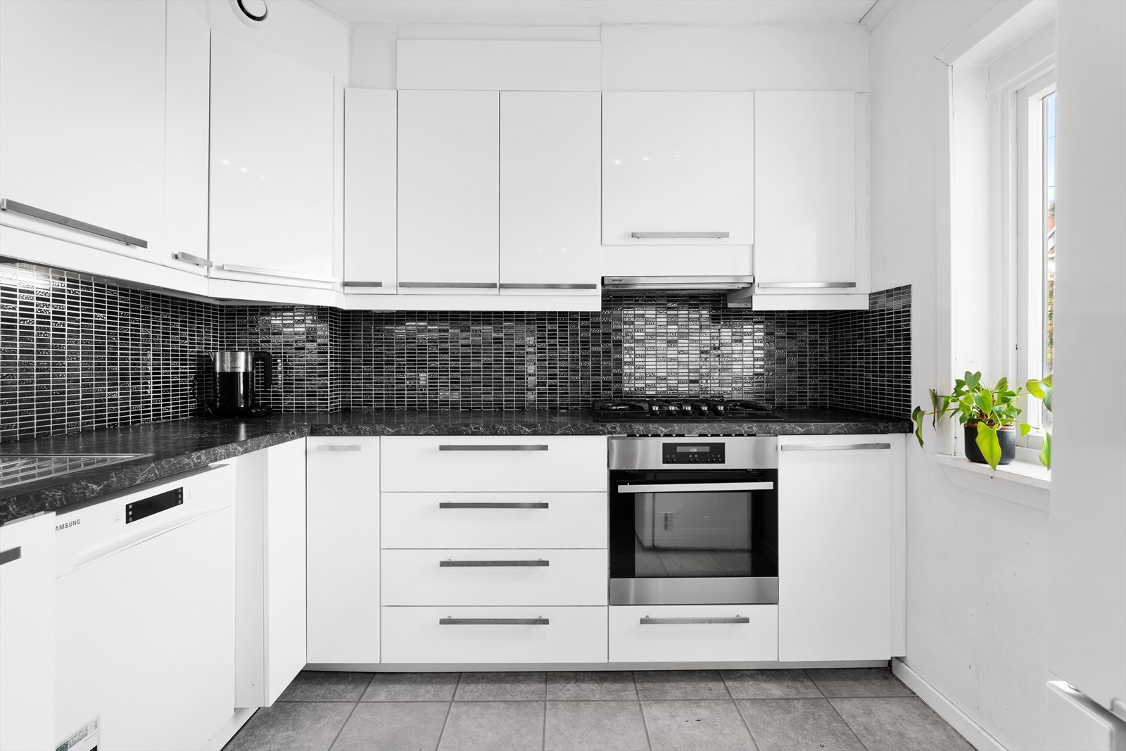 Trivelig kjøkken fra 2013 som består av innredning med hvite glatte fronter på skuffer og skapdører Galleribilde