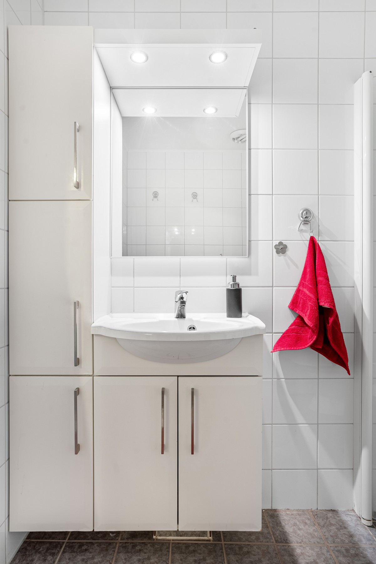Badet har innredning med mye skapplass.