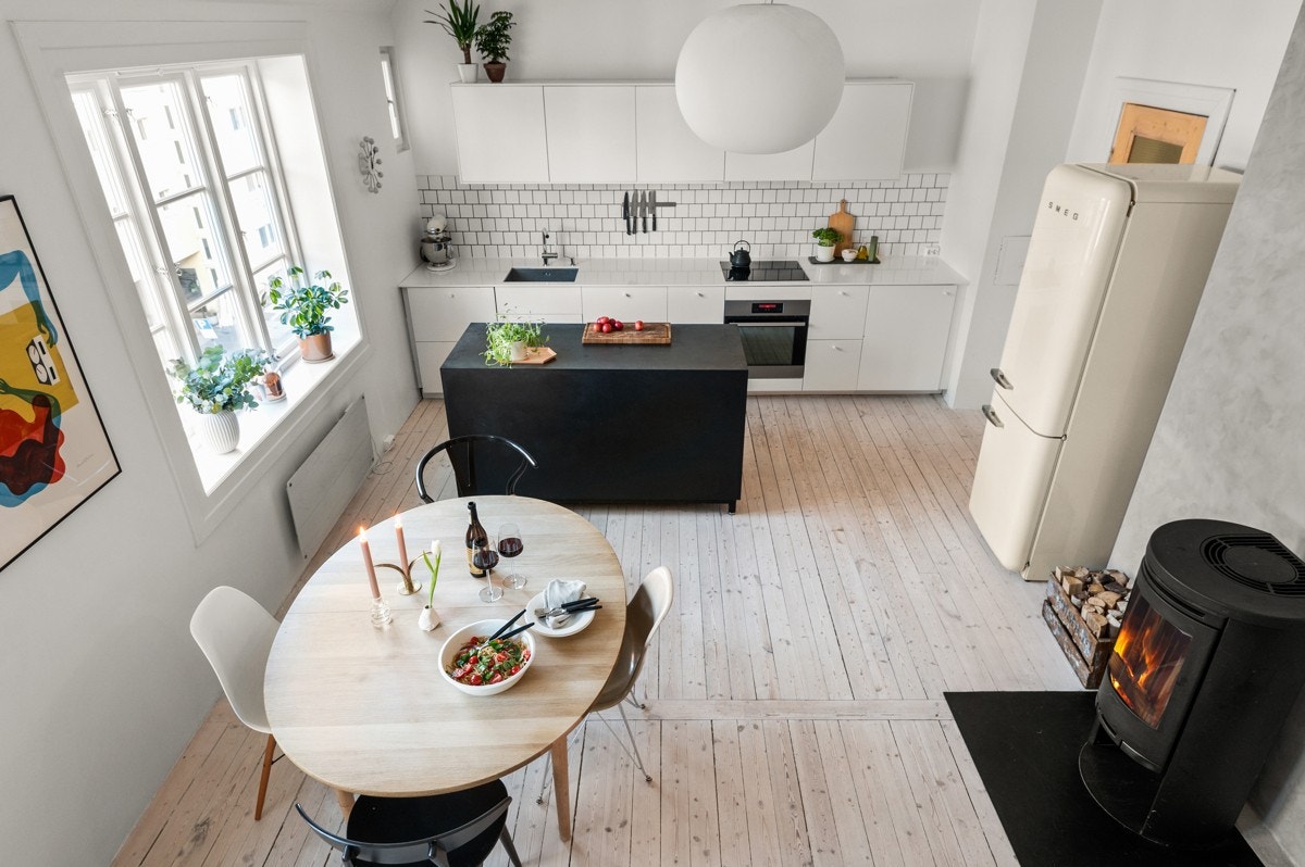 Romslig spisestue med åpen kjøkkenløsning. Kjøkkenøyen er spesiallaget av møbelsnekker i gjennomfarget sort MDF. Galleribilde