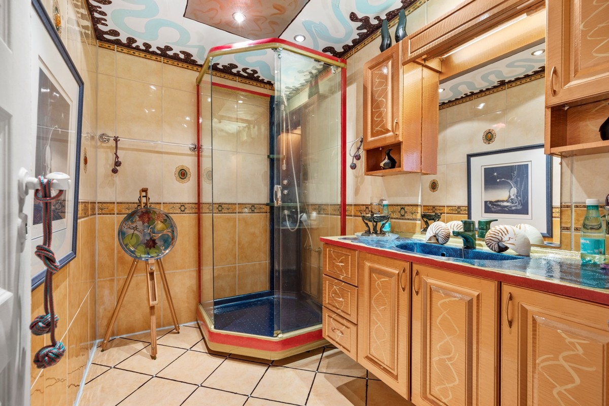 Bad med god plass til oppbevaring og dusjkabinet. Varmekabler i gulv. Flisene er spesiallagd i Italia og er meget kostbare. Galleribilde