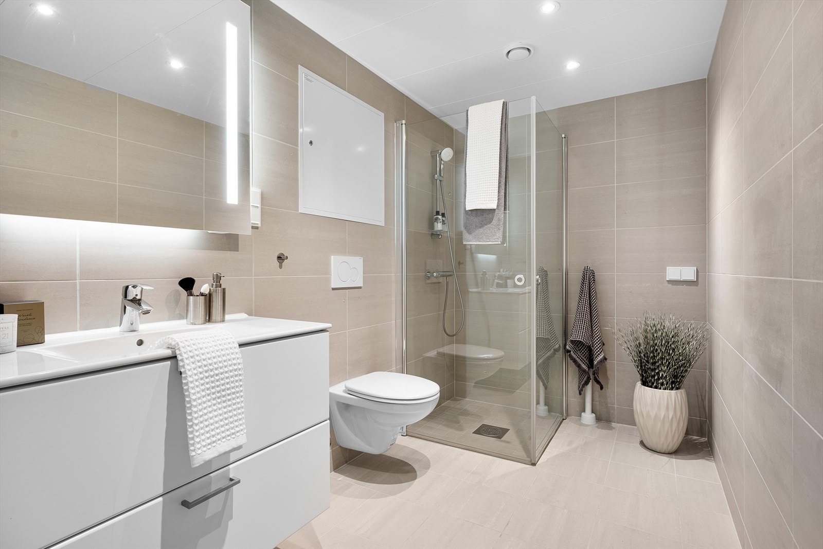 Badet er gjennomført i moderne og pen stil. Arealeffektivt innredet. Det er fliser på alle vegg- og gulvflater Galleribilde