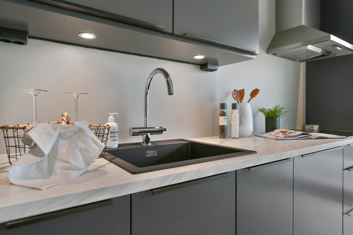 Innredningen har grå slette fronter, laminert benkeplate og downlights under overskap. Galleribilde