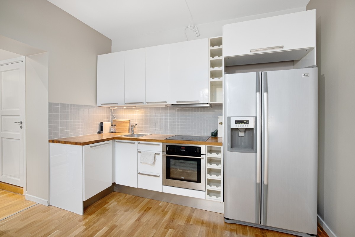 Hvit høyglans kjøkkeninnredning med glatte skapdører og skuffefronter. Galleribilde