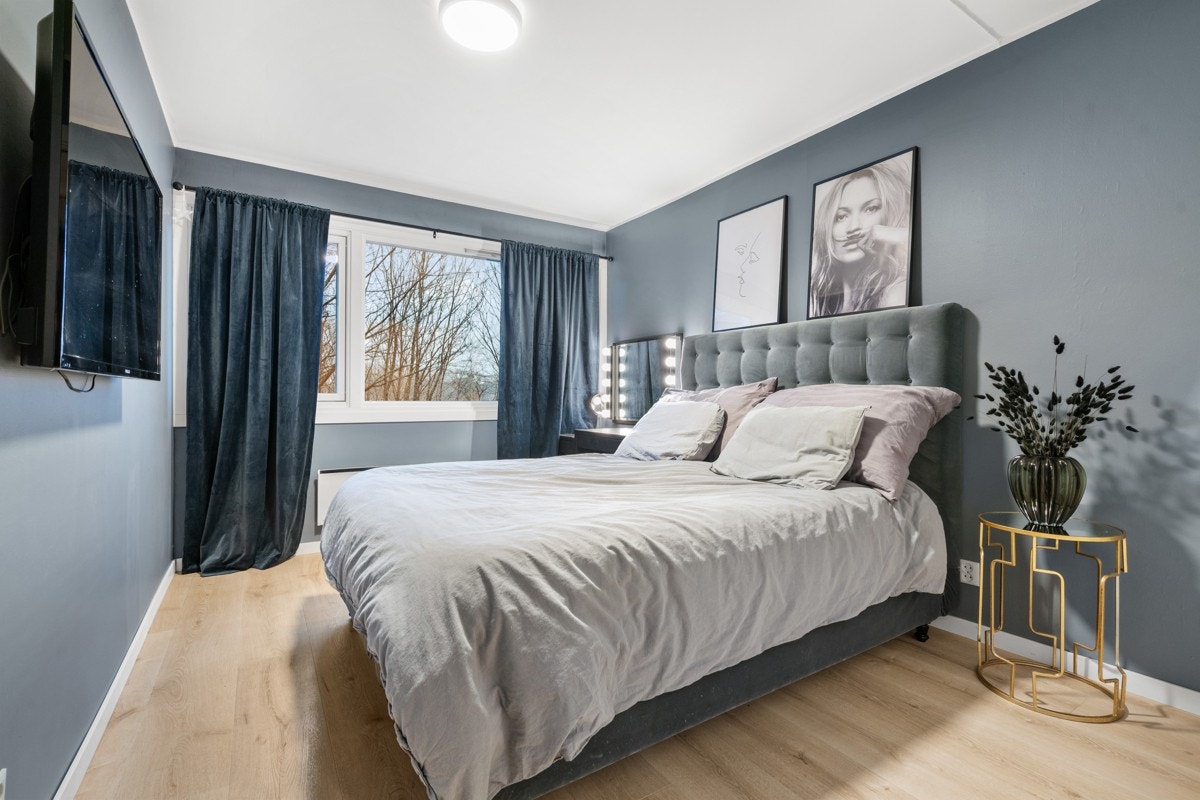 Pent oppusset soverom med god plass til dobbeltseng Galleribilde