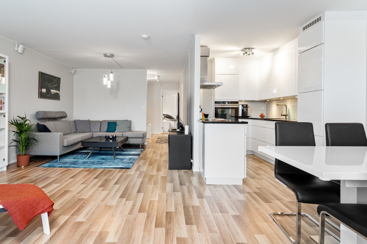 Kjøkken og stue/spisestue ligger i delvis åpen løsning for en sosial og livlig leilighet. Galleribilde