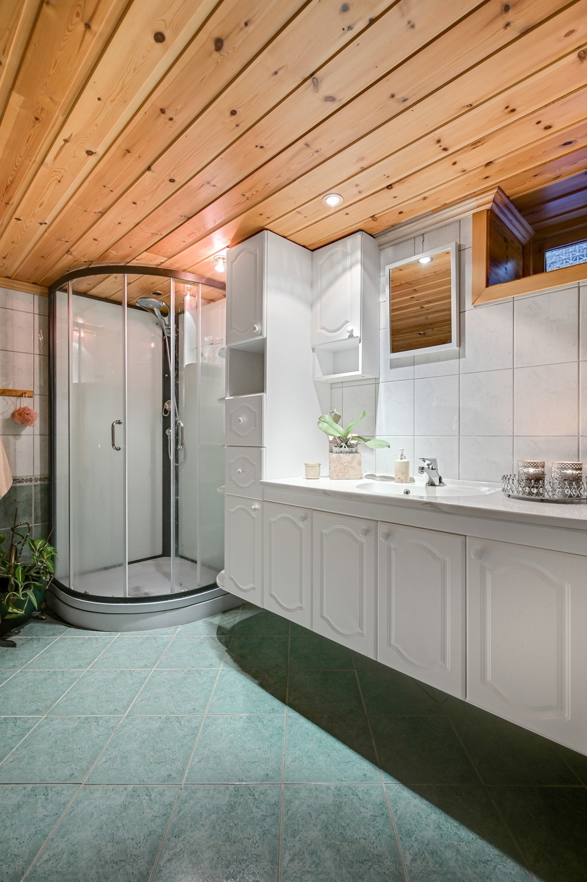 Badet i kjelleren er innredet med dusjkabinett, stor baderomsinnredning, klosett, opplegg for vaskemaskin og badekar Galleribilde