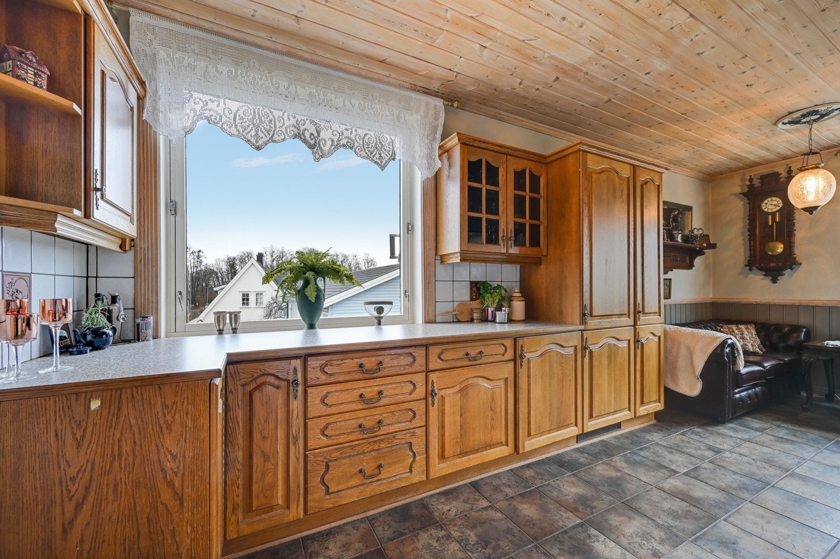 Fliser over kjøkkenbenken og mye innredning så man har god plass til oppbevaring av diverse kjøkkenredskaper Galleribilde