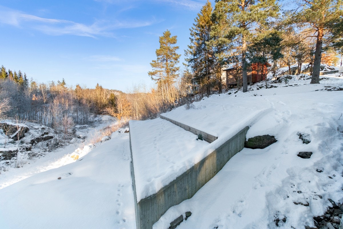 Tomta er opparbeidet med fine grøntarealer, solide murer og blomsterbed Galleribilde