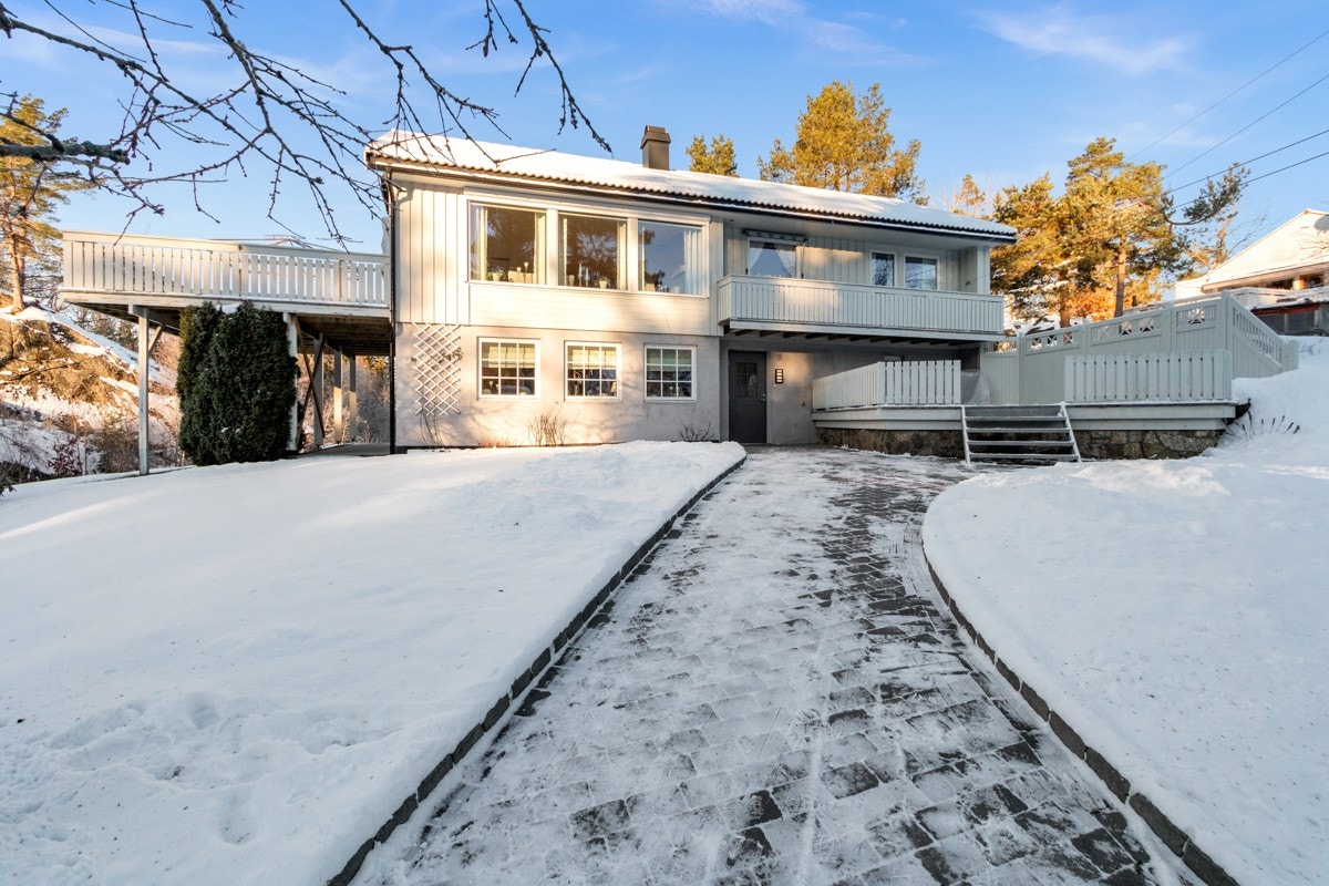 Pent opparbeidet tomt med brosteinsbelagt tun fra garasje og opp til inngangsparti Galleribilde