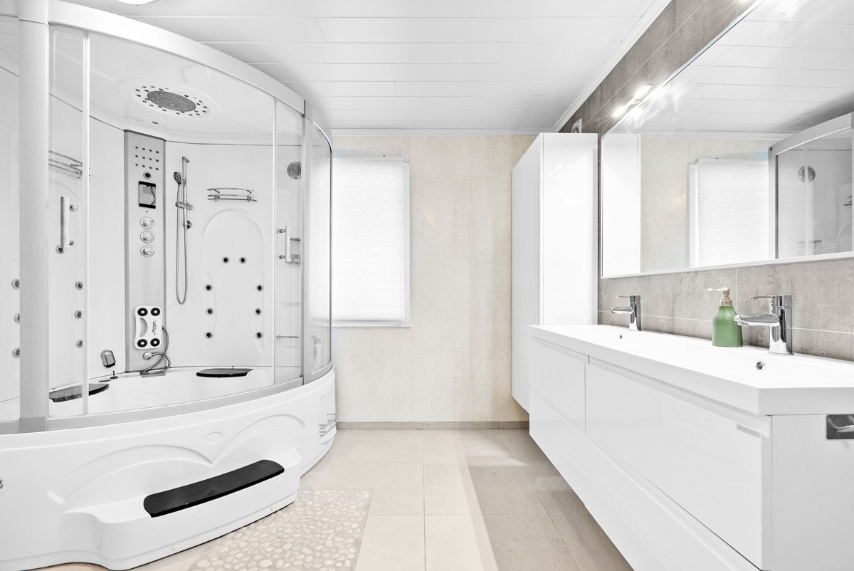 Bad/vaskerom på hovedplan er av god størrelse med et romslig dusjkabinett og dobbel servant Galleribilde
