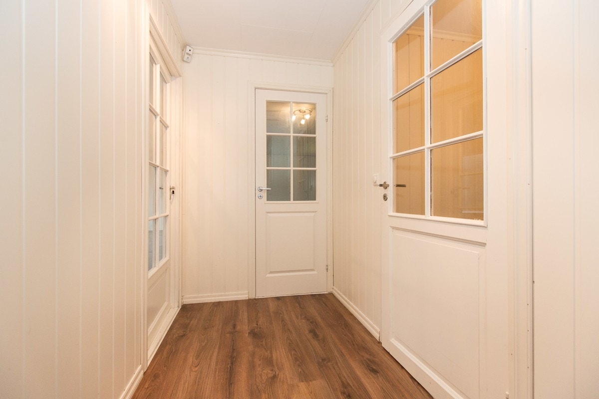 Man entrer boligens 1. etasje ved praktisk vindfang på eiendommens vestre side. Videre fra vindfanget kommer man inn til en lys gang. Galleribilde