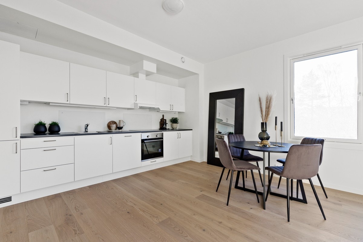 Kjøkkenet er av slette hvite overflater med god plass til spisestue. Galleribilde