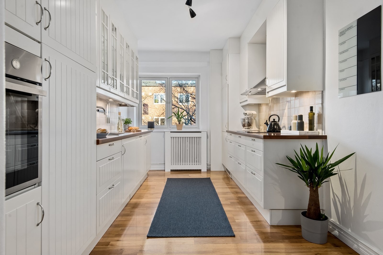 Pent og lyst kjøkken med integrert koketopp med ventilator, stekeovn, oppvaskmaskin og kombiskap. Galleribilde