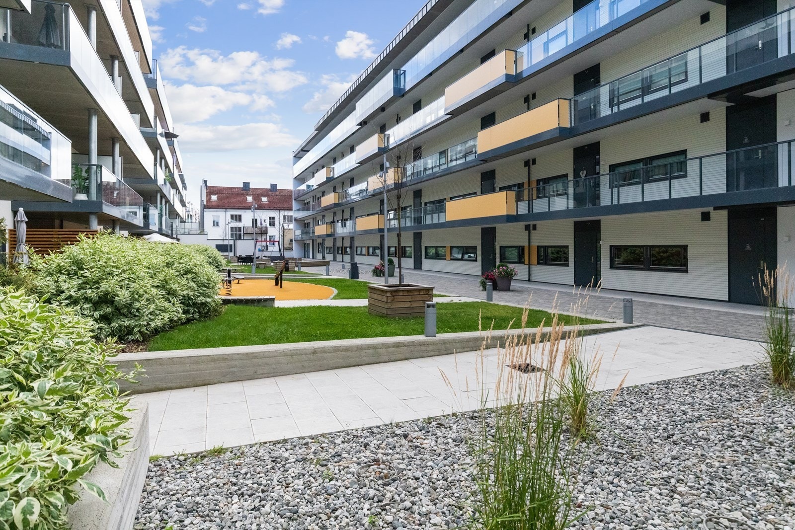 Fellesarealet består av frodig grøntområde, lekeplasser og sitteplasser. Galleribilde