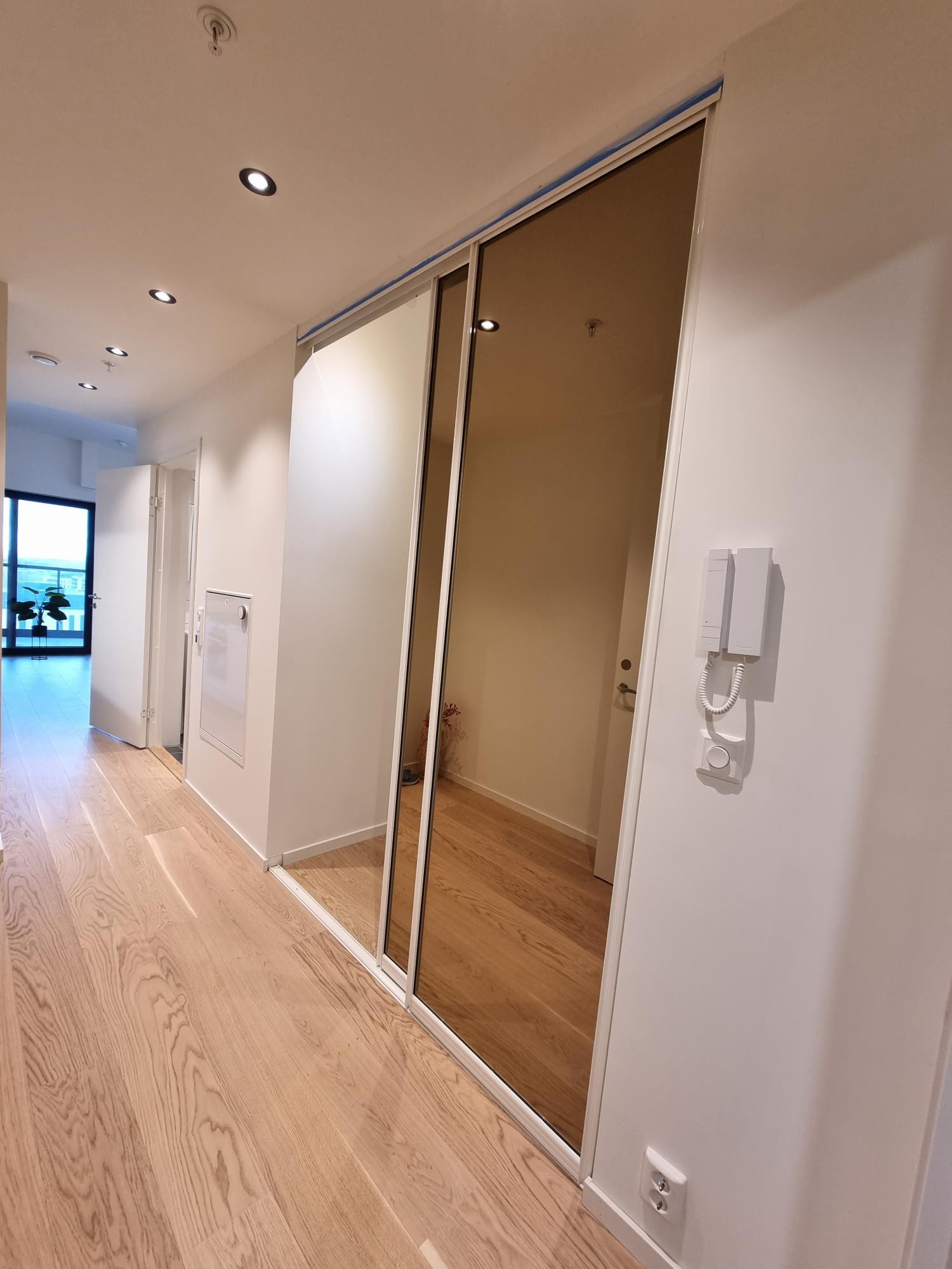 Entrè med inngang til romslig sovealkove med skyvedører Galleribilde