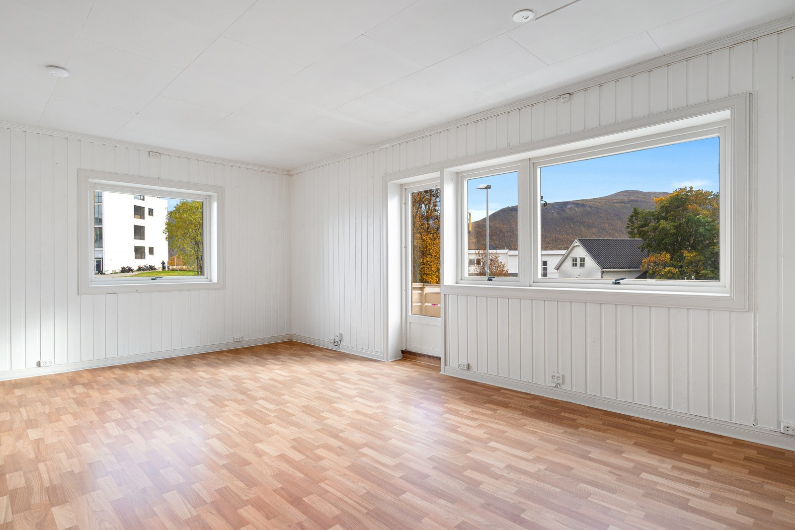 Lys stue med god plass til sofagruppe og tilhørende møblement. Utgang til veranda fra stuen.