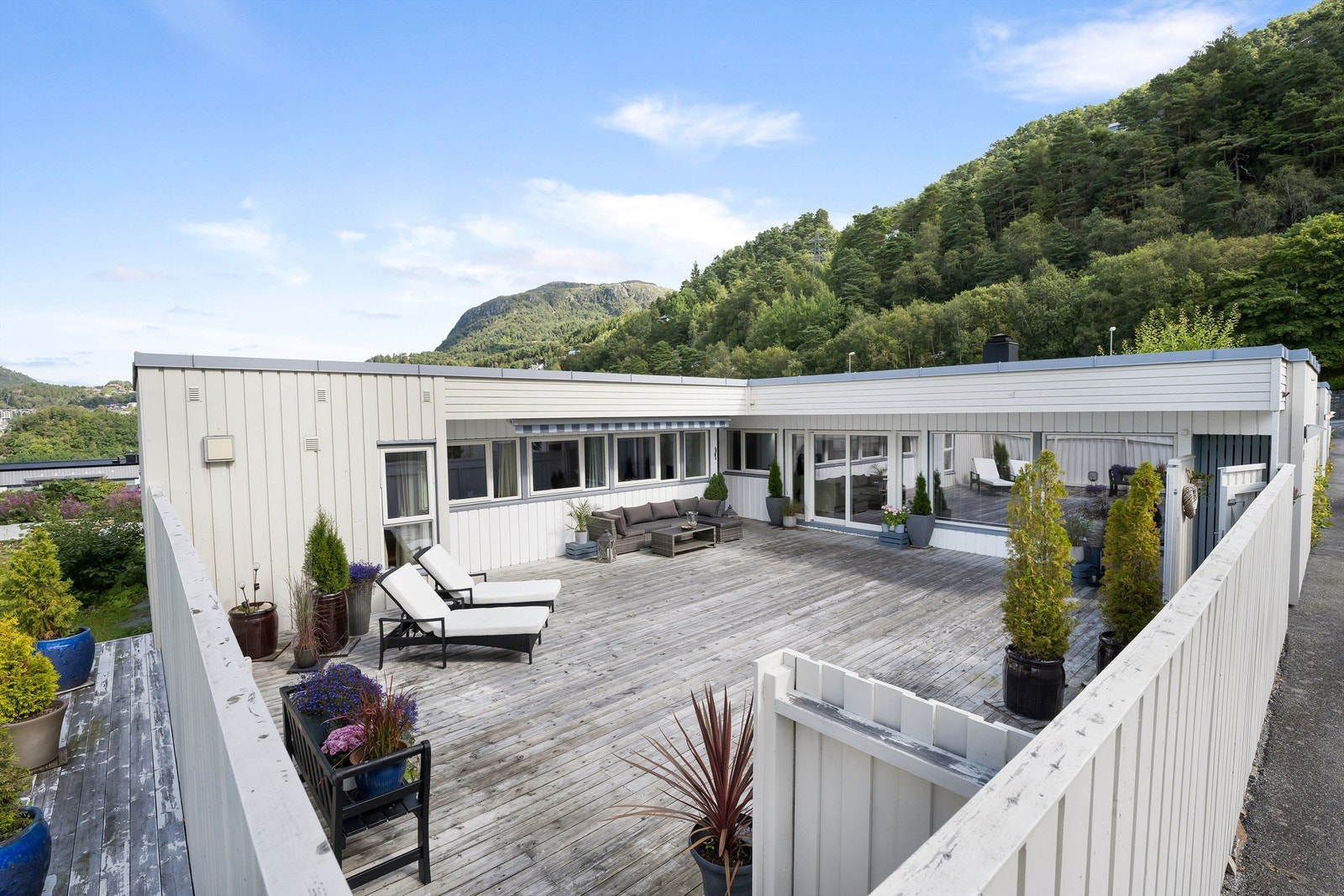 Store vindusflater inn i boligen fra uteplassen. Galleribilde
