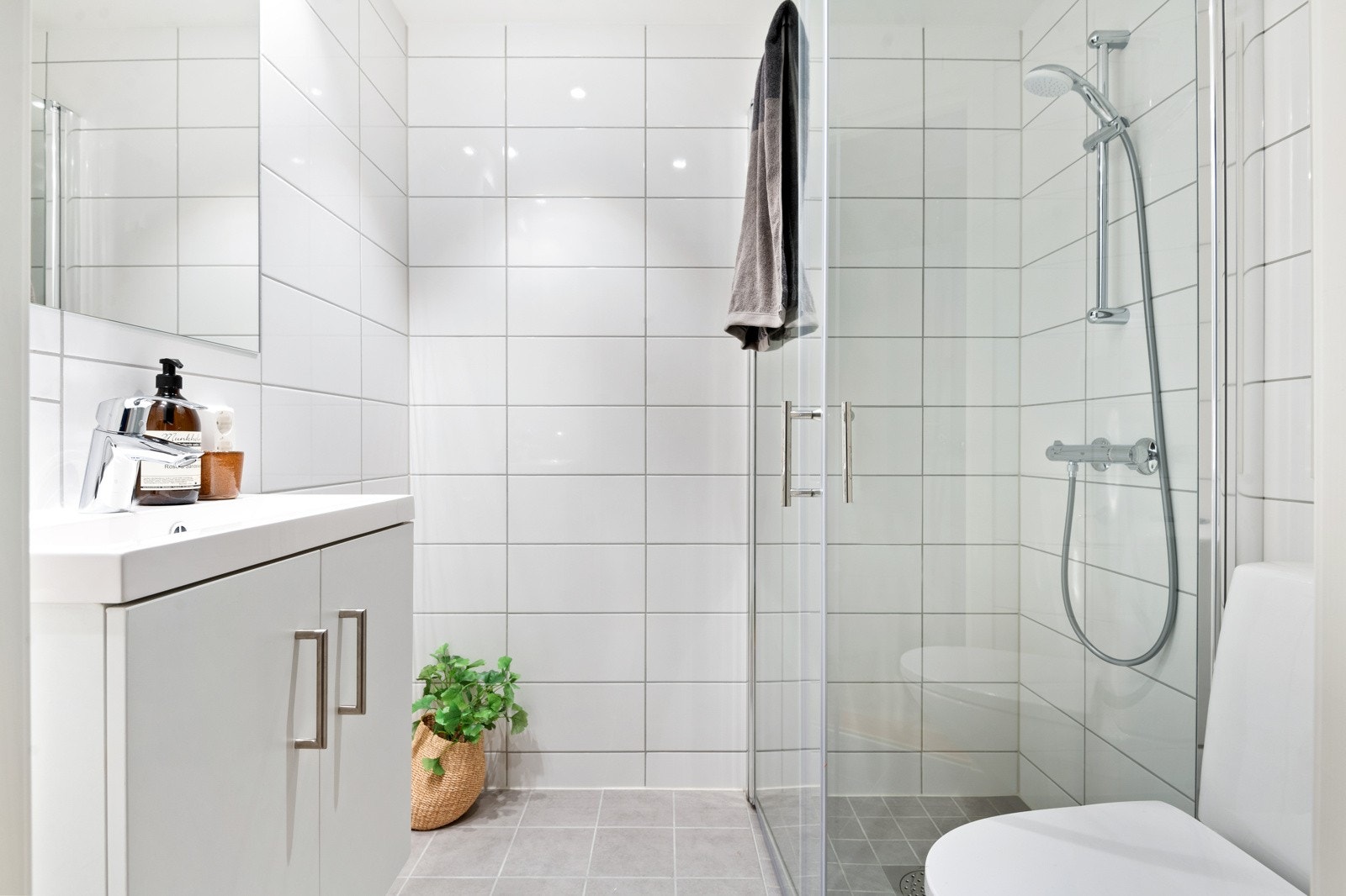 Det private badet er flislagt med vannvåren gulvvarme. Dusjhjørne med svingbare glassdører og pen baderomsinnredning. Galleribilde