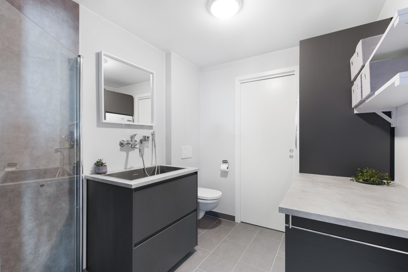 Vaskerommet er praktisk innredet med skaper og skuffer til lagring, ekstra dusj samt toalett. Galleribilde