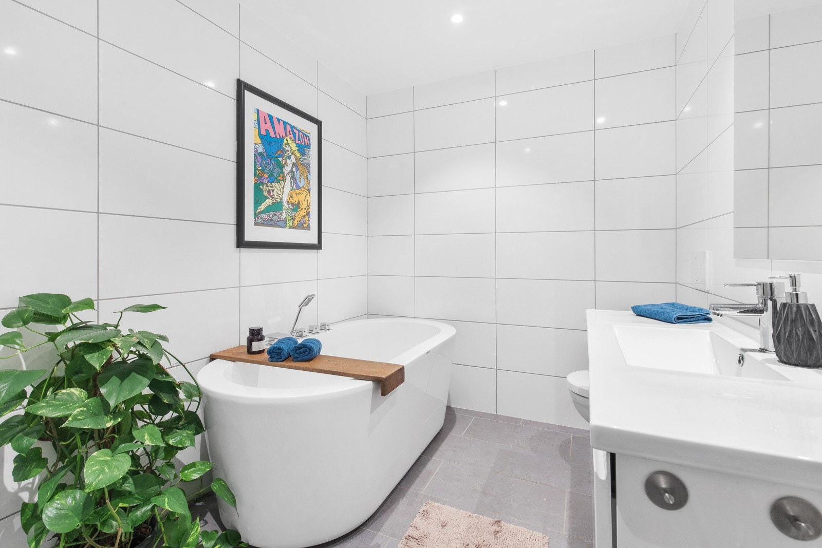 Meget pent bad med fliser på gulv og vegg. Her har man både badekar og dusjhjørnet med glassvegger Galleribilde