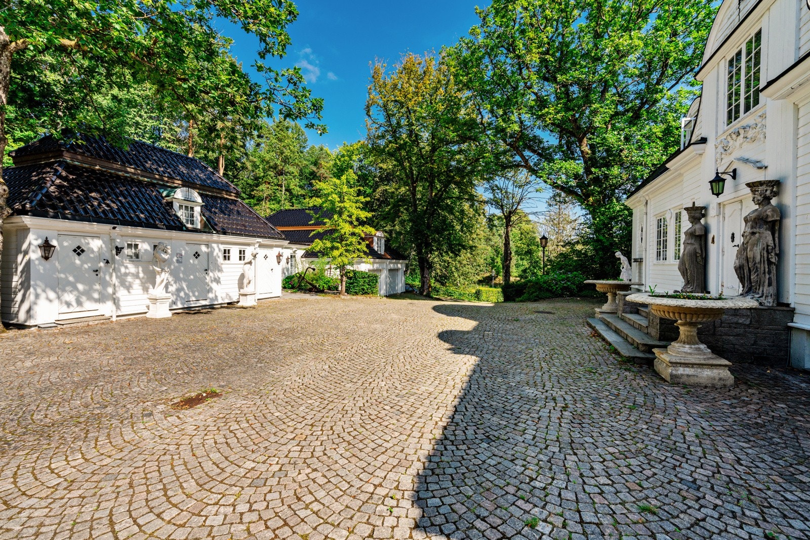 Fra den store gårdsplassen mellom huset og garasjebygningen Galleribilde