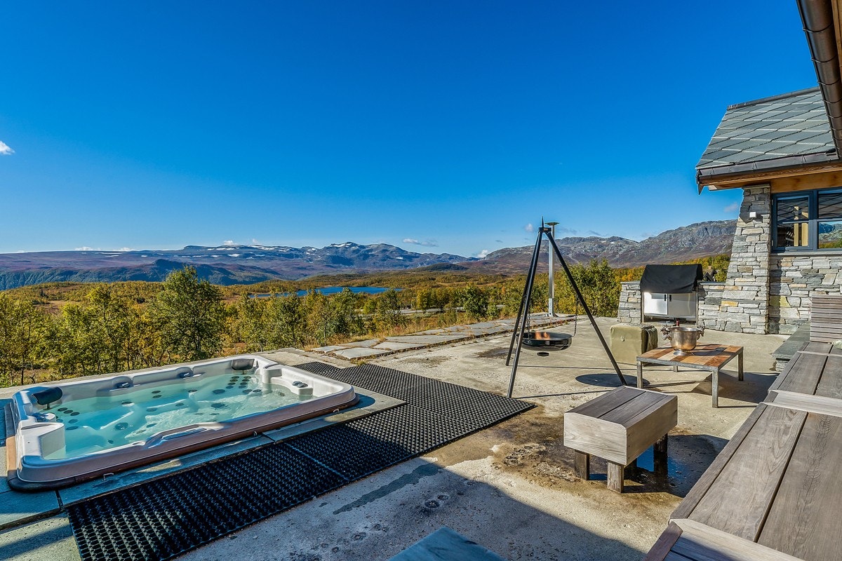 Nydelig utsikt som kan nytes fra både inne og ute - Den store uteplassen med adkomst både fra hytte og anneks har betong- og skiferdetaljer som gjør det lett å holde rent Galleribilde