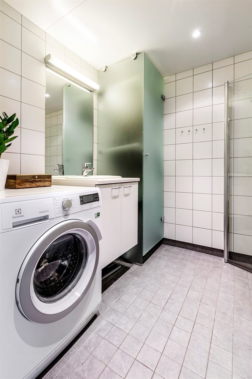 Opplegg for vaskemaskin og tørketrommel. Det er installert tørkeskap bak dør i frosset glass. Galleribilde