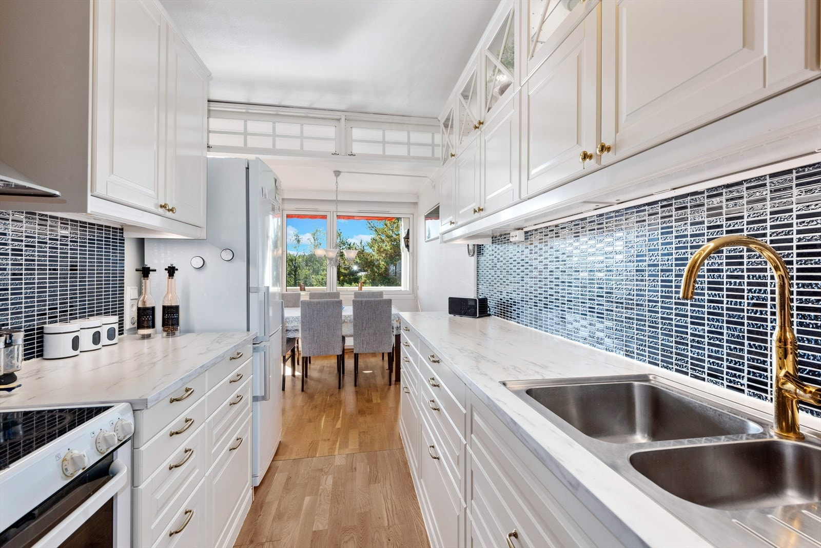 Kjøkkeninnreding med hvite profilerte fronter. Galleribilde