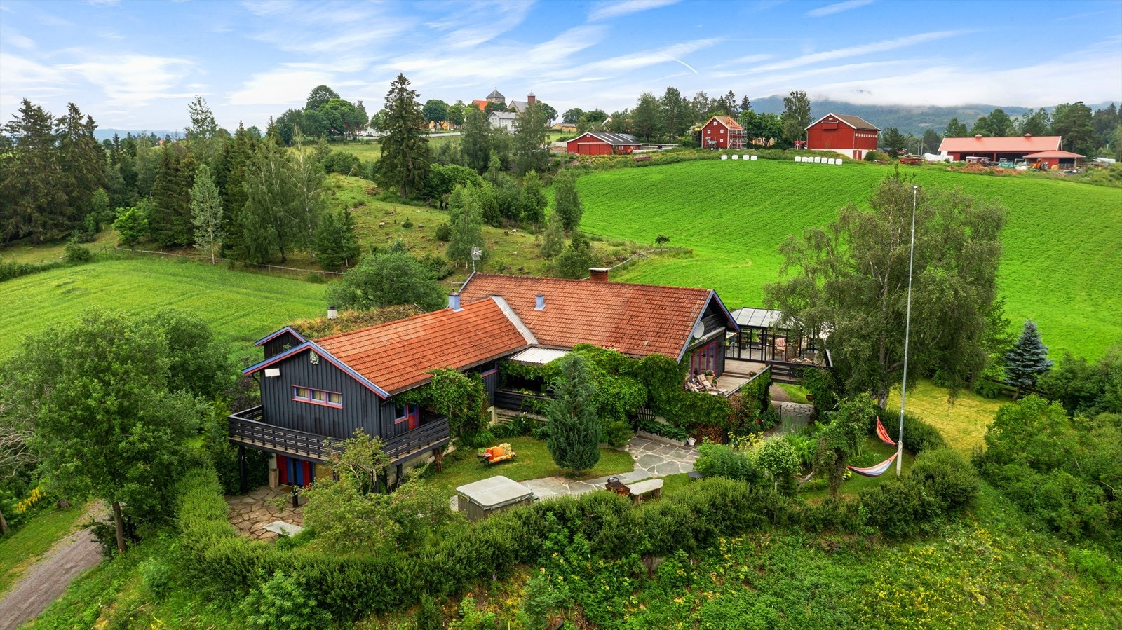 Eiendommen ligger fritt og usjenert til i Helgumsdalen, omgitt av gårdsbruk og dyrket mark. I bakgrunnen ser vi Granavollen og Søsterkirkene. Galleribilde
