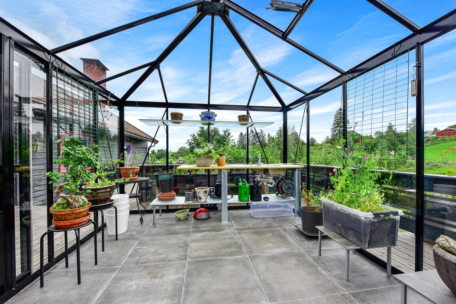 Et stort vekst- og lysthus er plassert på terrassen. Galleribilde