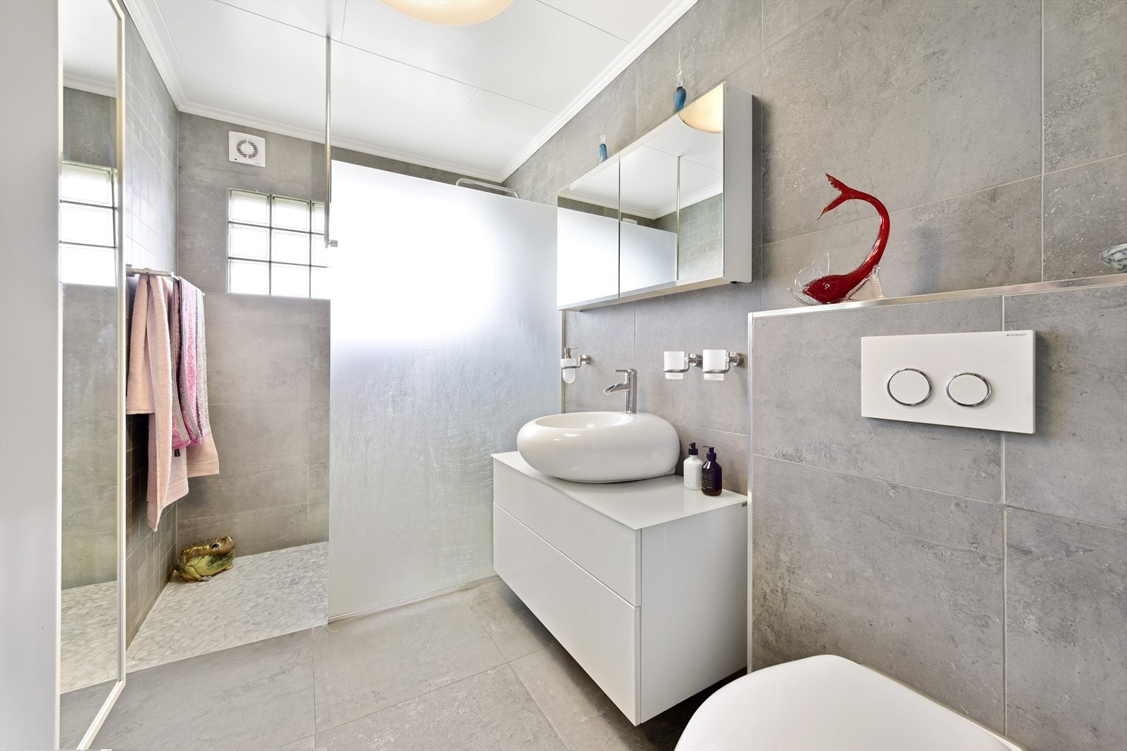 Badet er nylig pusset opp med flislagte vegger og gulv. Stort dusjhjørne, vegghengt toalett og store speilflater. Galleribilde