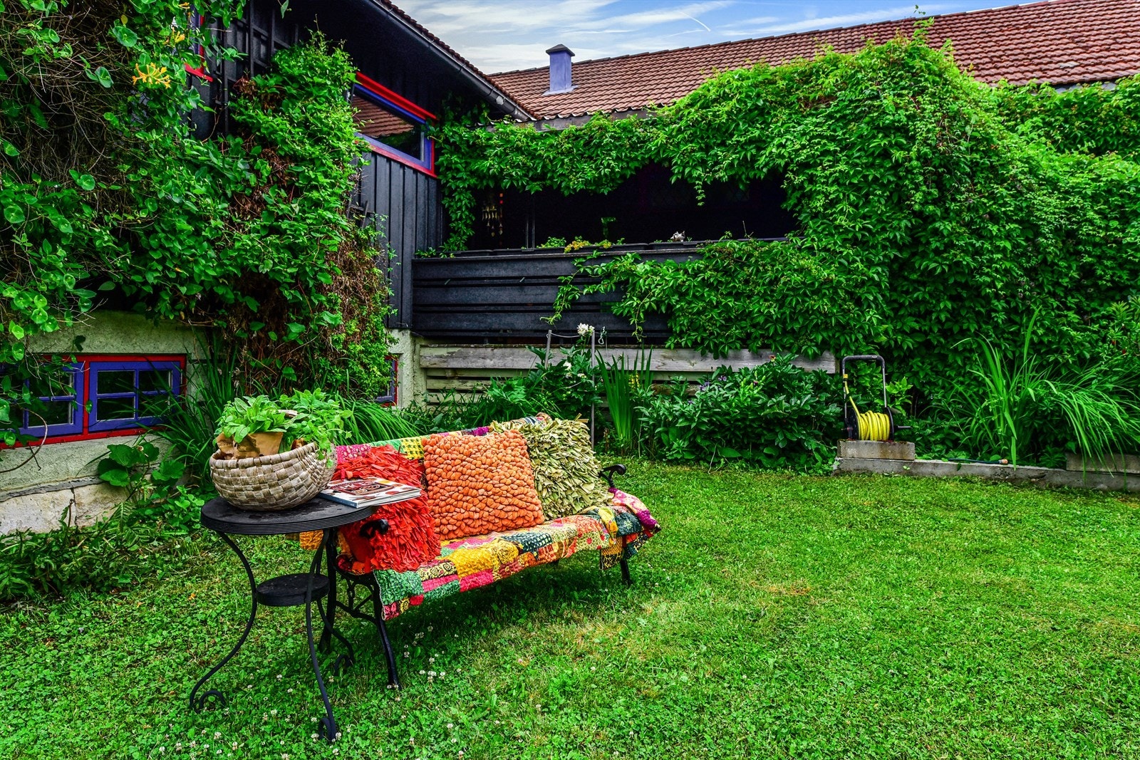 Hagen grønn og frodig, og villvinen kryper villig oppover veggene. Galleribilde