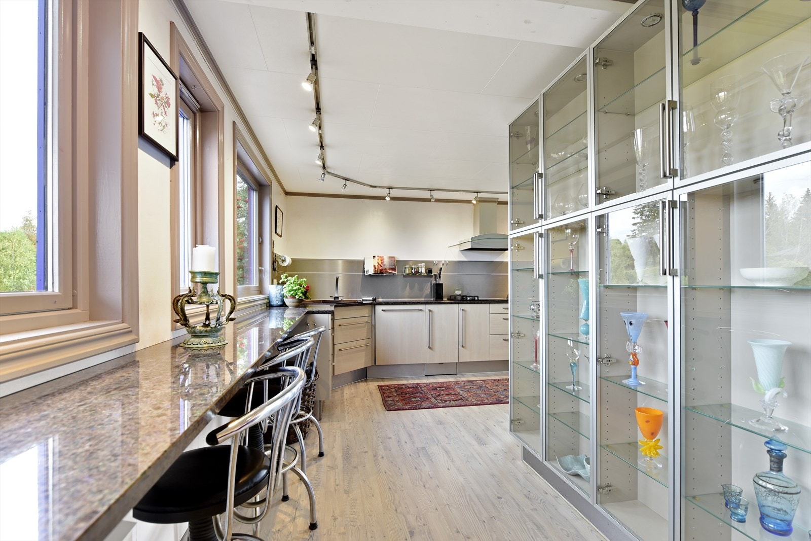 Veggen bak plassen med barkrakker er dekket med vitrineskap fra gulv til tak. Her kan man stille ut det fineste serviset og pyntegjenstander som fortjener dagens lys. Galleribilde