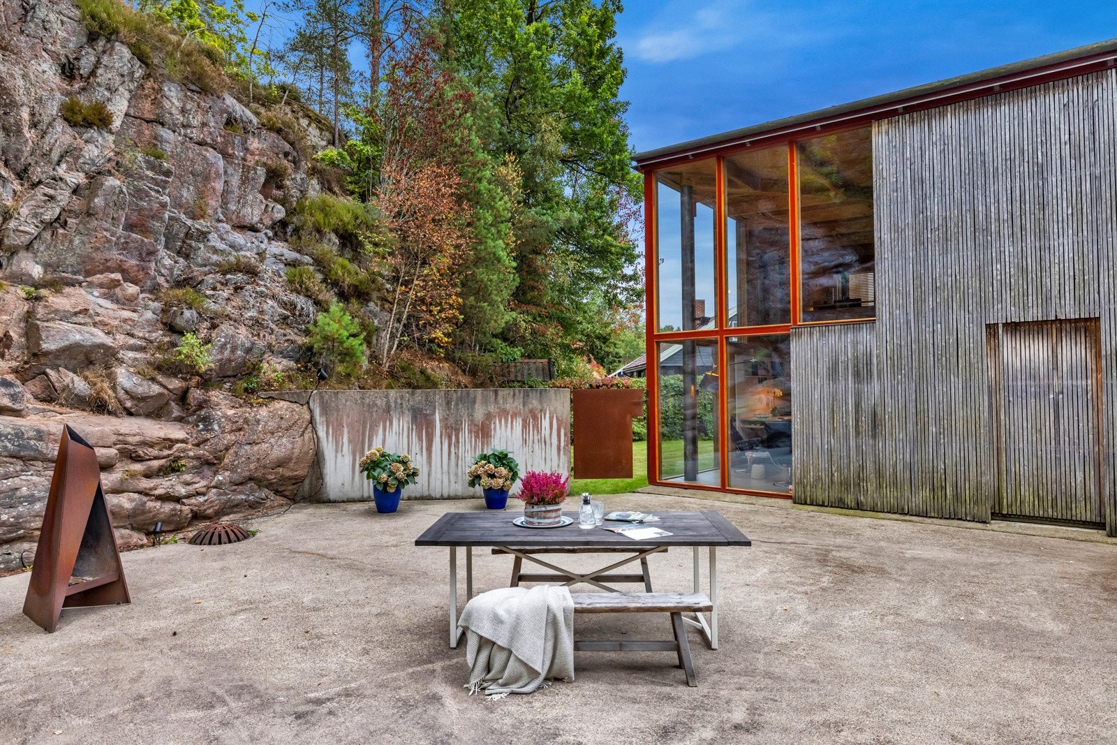 Atriumet er stort og flatt betongdekke, med skjermende vegger og vegetasjon mot naboene. Den er også gjerdet inn av hensyn til en hund som har kunnet gå løs. Galleribilde