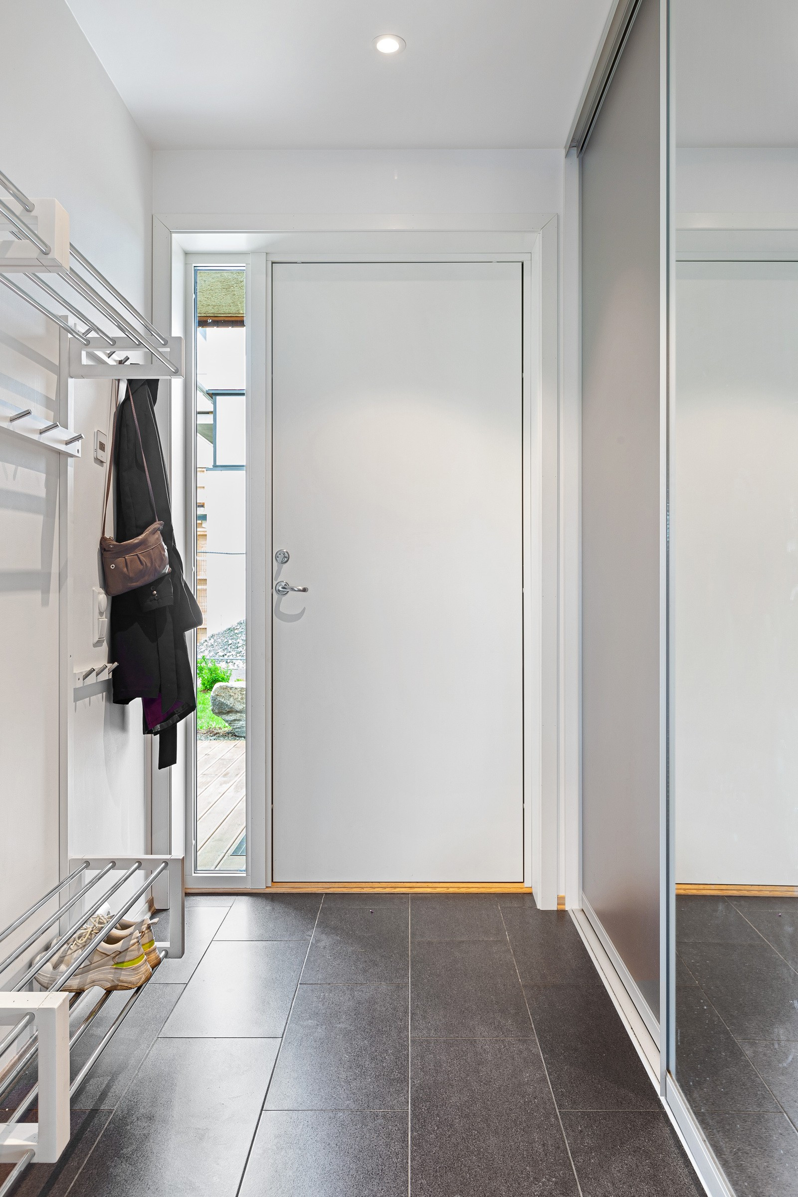Velkommen inn! Gangen gir et godt førsteinntrykk av boligen med flislagt gulv, downlights i tak og stor skyvedørsgarderobe