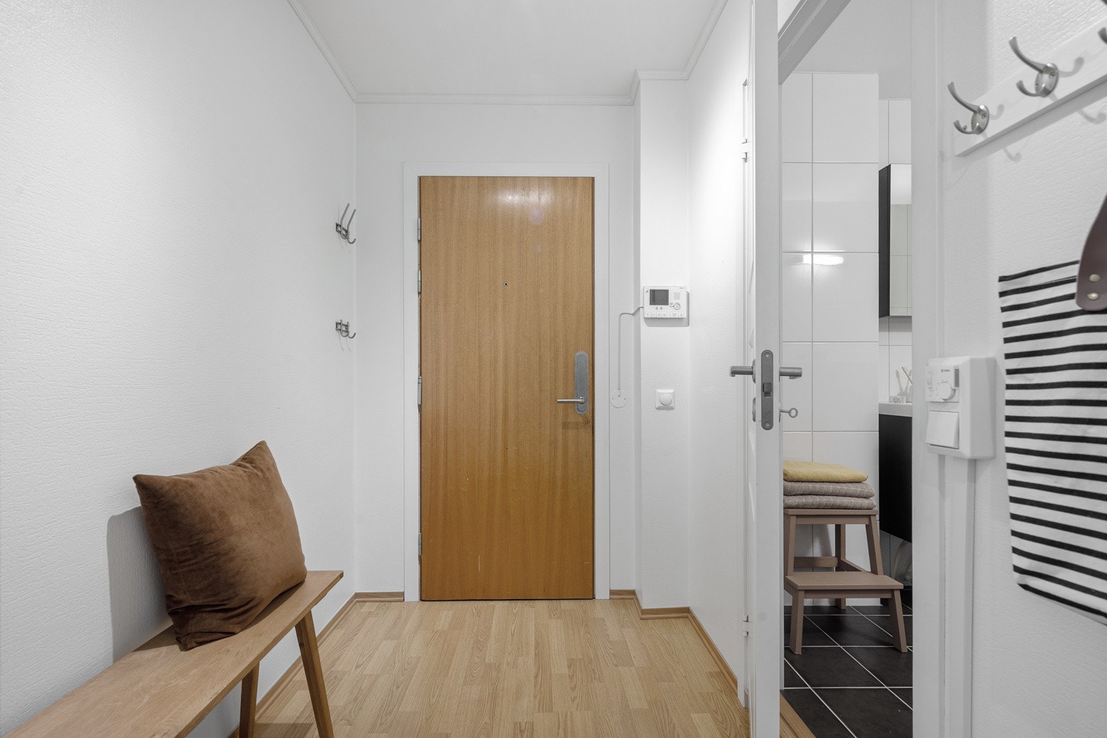 Ved ytterdøren er det montert dørcalling og litt lengre inn er det mulighet for en sittebenk. Galleribilde