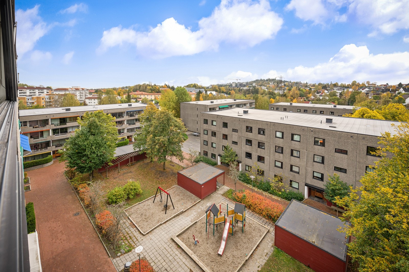 Skjermet mellom blokkene er det sitteplasser og en fin lekeplass til de små. Galleribilde