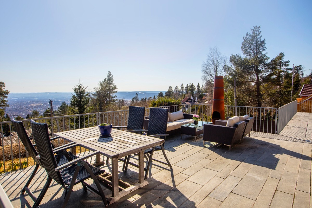 Utgang til flislagt panoramaterrasse både fra stue og kjøkken Galleribilde