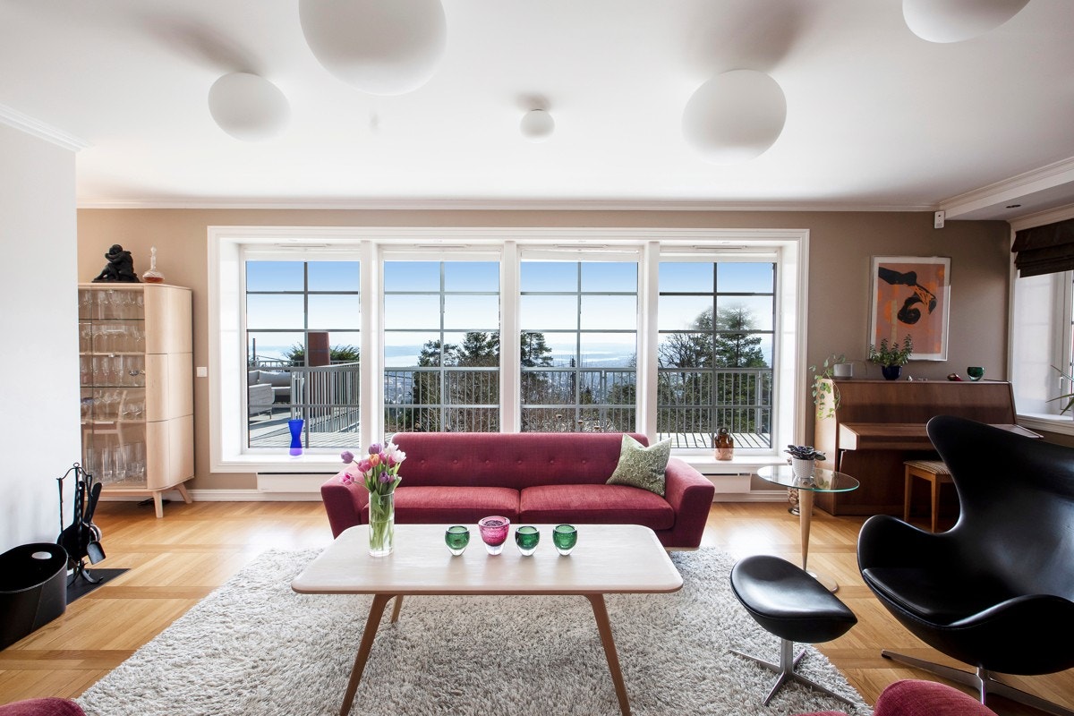 Byen og fjorden rammet inn i det store panoramavinduet i stuen Galleribilde