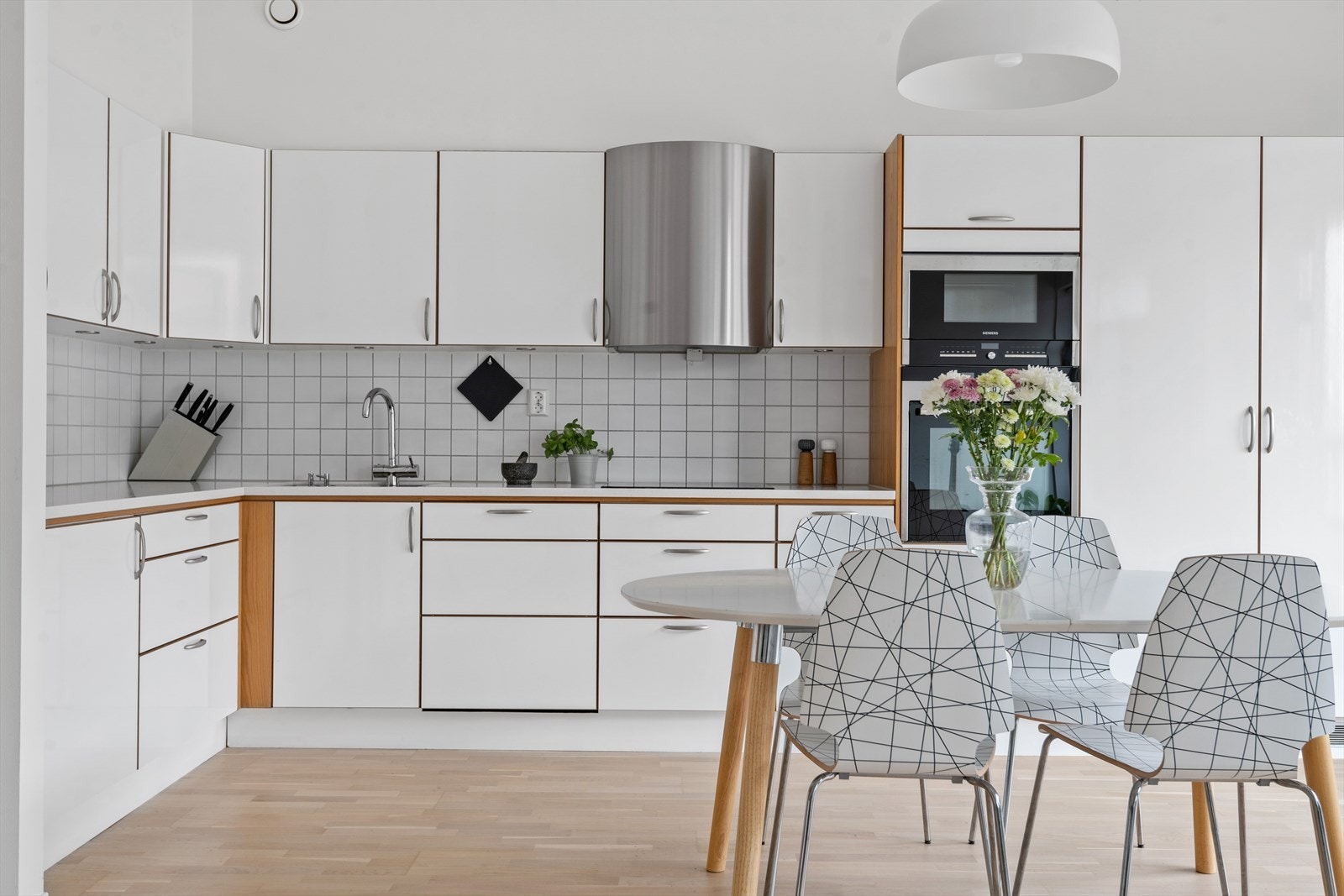 Påkostet kjøkken med bla. kompositt benkeplate, kjøkkenvifte fra Røroshetta, dobbelt kjøleskap/fryser fra Miele og integrerte hvitevarer fra Siemens Galleribilde