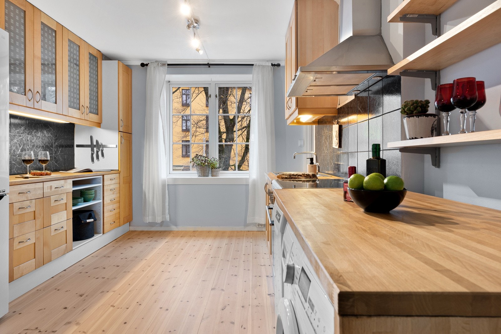 Flott kjøkken på 15 m² med praktisk utforming for ekstra god benk- og skapplass Galleribilde